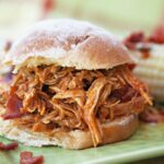 BBQ Pulled Chicken on a roll on a green plate.