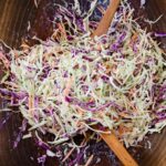 Creamy Coleslaw in a wooden salad bowl with salad servers.