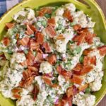 Dill Cauliflower Salad in a green ceramic dish with a blue checkered napkin.