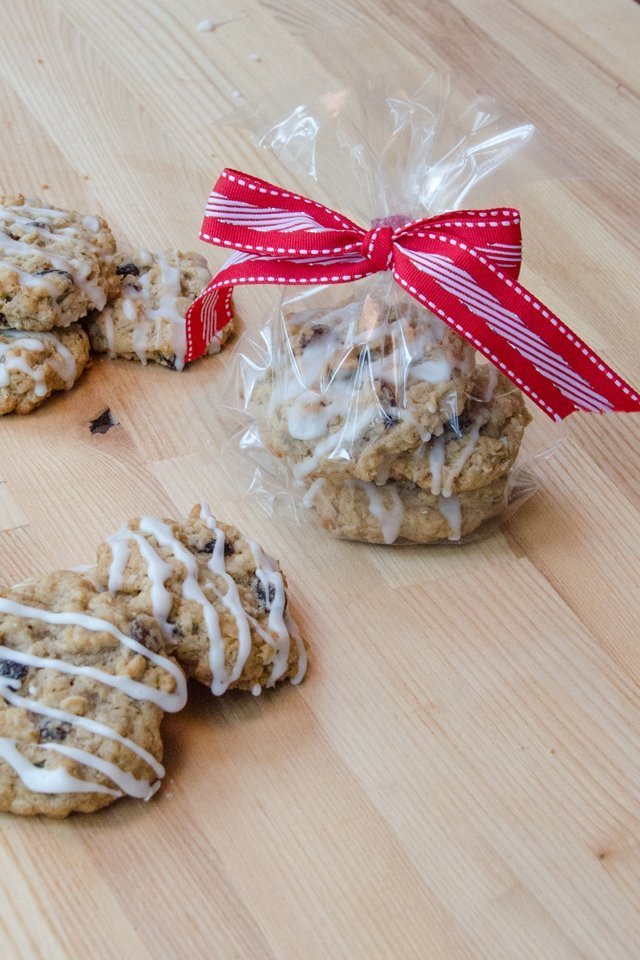 iced Oatmeal Raisin Cookies wrapped in cellophane and tied with a red ribbon.