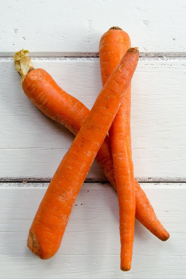 Carrots on white wood.