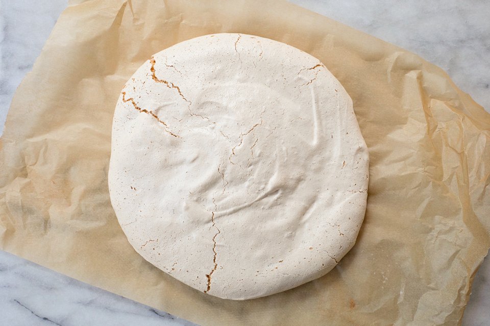 Undeocrated pistachio pavlova on a piece of parchment paper