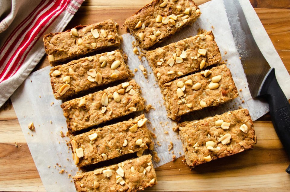 Peanut butter breakfast bars cut on a wooden cutting board.