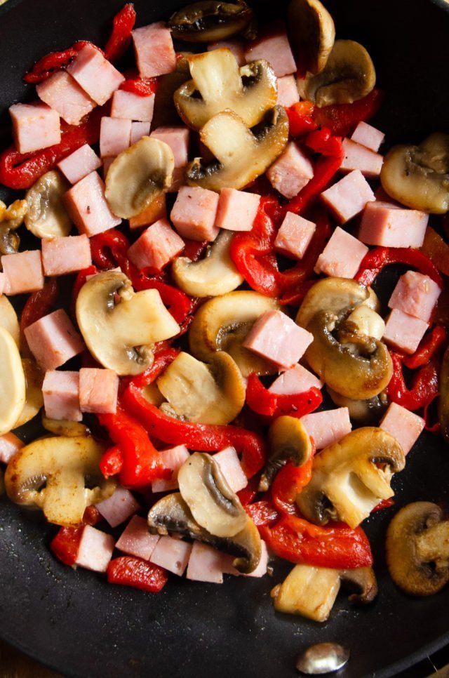 Ham, mushrooms and peppers cooked in a pan.