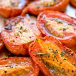 Close up of slow roasted tomatoes on a sheet pan.
