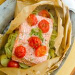 Sockeye Salmon en Papillote on a silver tray with a white towel.