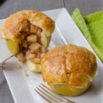 Stuffed Apple Pies on a rectangular white plate with a fork and a green napkin.
