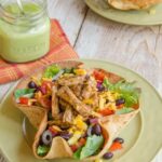 Turkey Tex Mex Salad in a tortilla bowl on a green plate.