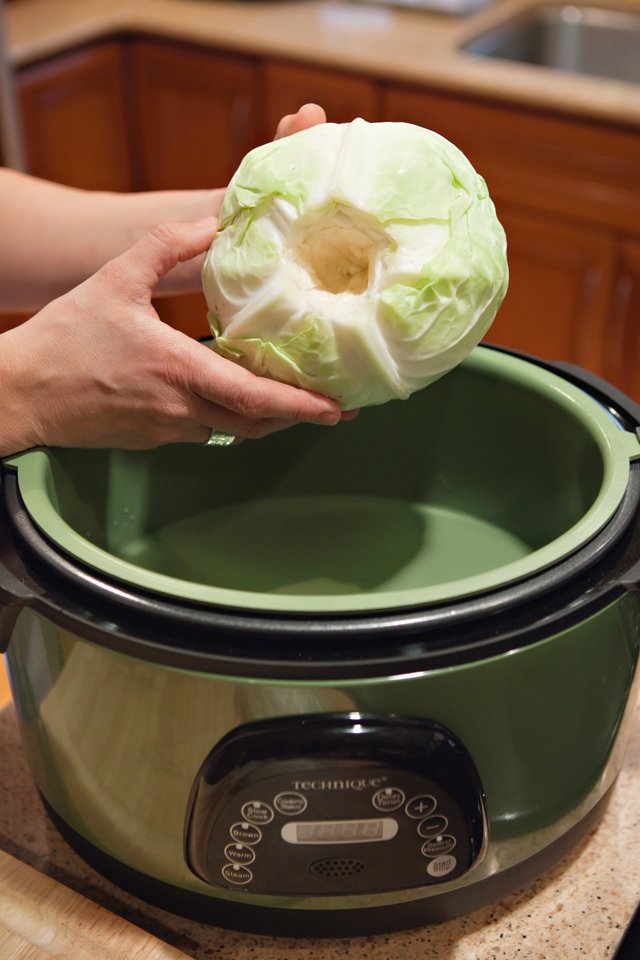 Cabbage going into a pressure cooker with the core removed.