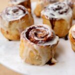 Air-Fried Cinnamon Rolls on a marble cake stand.