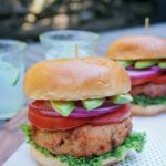 Salmon Burger on a polka dot napkin outside on a picnic table.