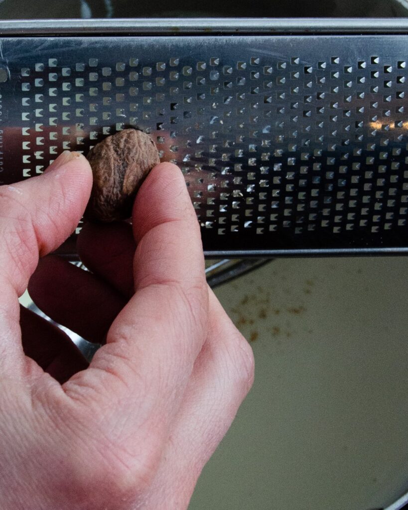 Grating fresh nutmeg on a grater.