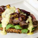 Open Faced Steak Sandwich on a white plate.