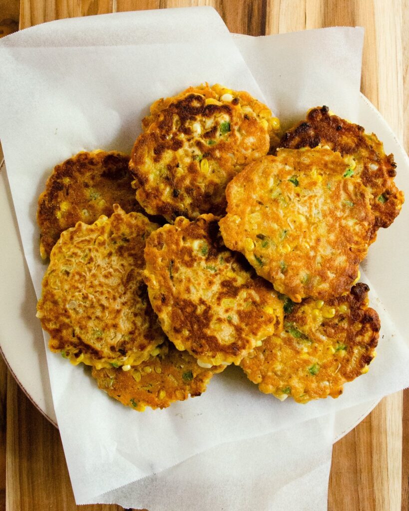 Finished spicy corn cakes stacked up on a plate.