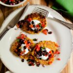 Spicy Corn Cakes on a white plate with black bean salsa on top.
