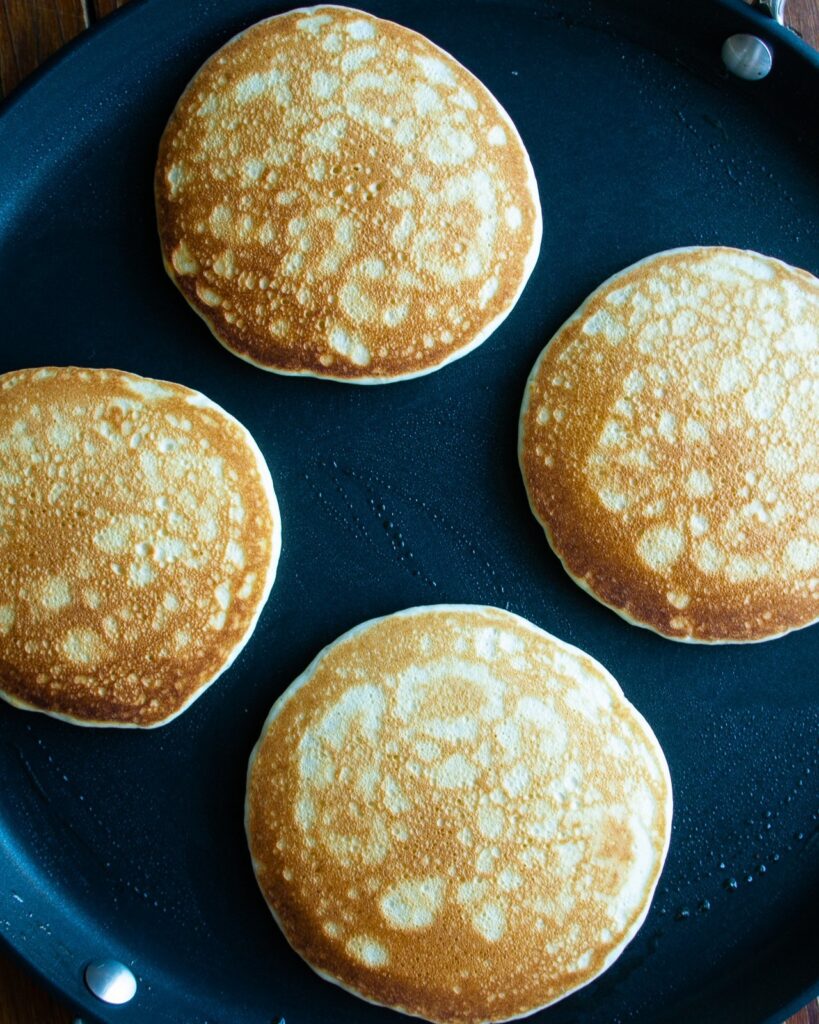 4 pancakes, cooked on one side with a lacey pattern on top.