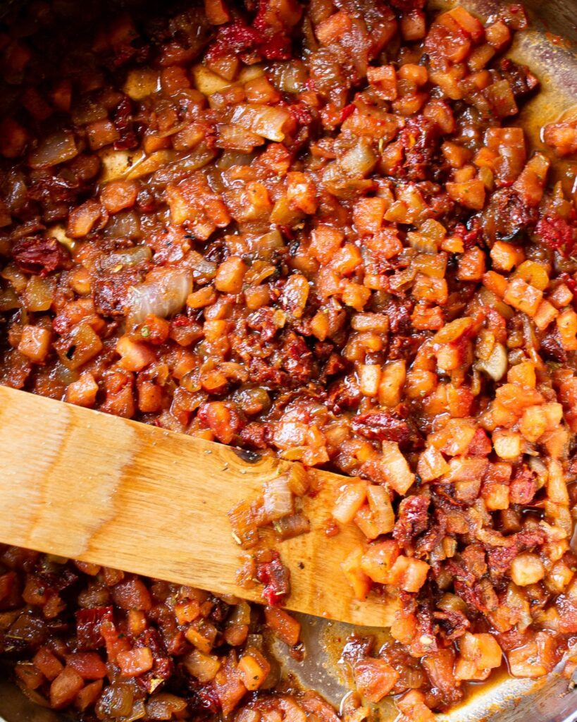 Tomatoes, onions and other ingredients in a saute pan.