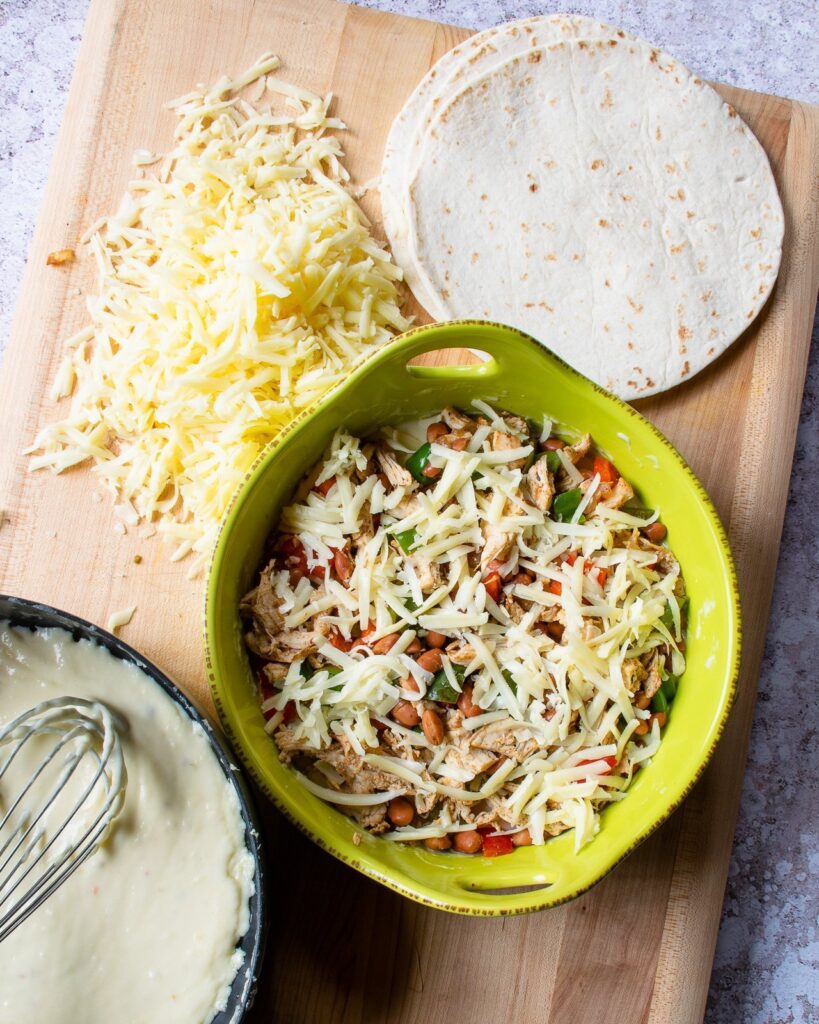 Building white turkey enchilada pie - tortillas, cheese sauce, filling and a casserole dish.