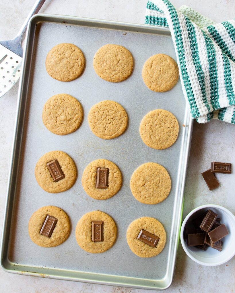 A baking sheet with s'mores cookies on it, some with chocolate and some without.