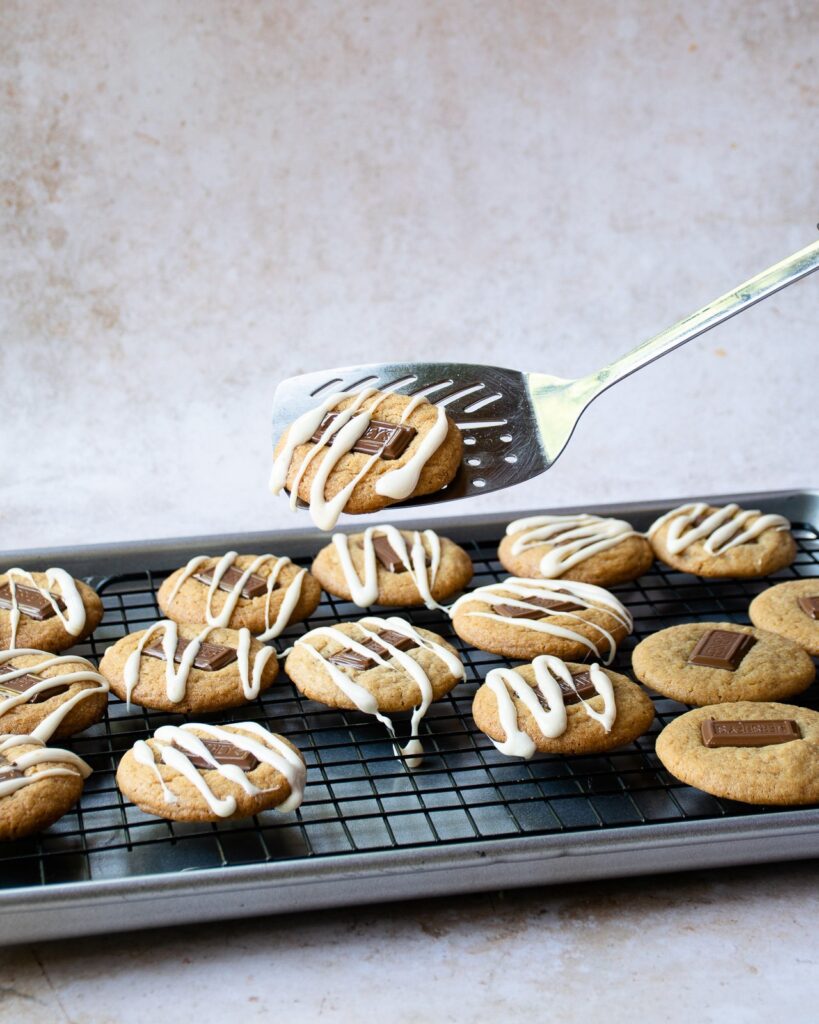 A spatula lifting a s'mores cookie off a cooling rack.