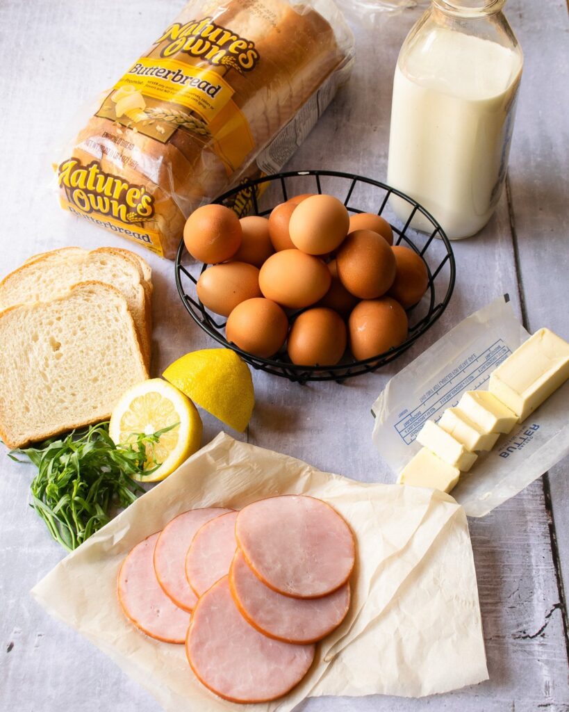 Ingredients for bread puddings - eggs, Canadian bacon, butter, milk, bread and lemon.