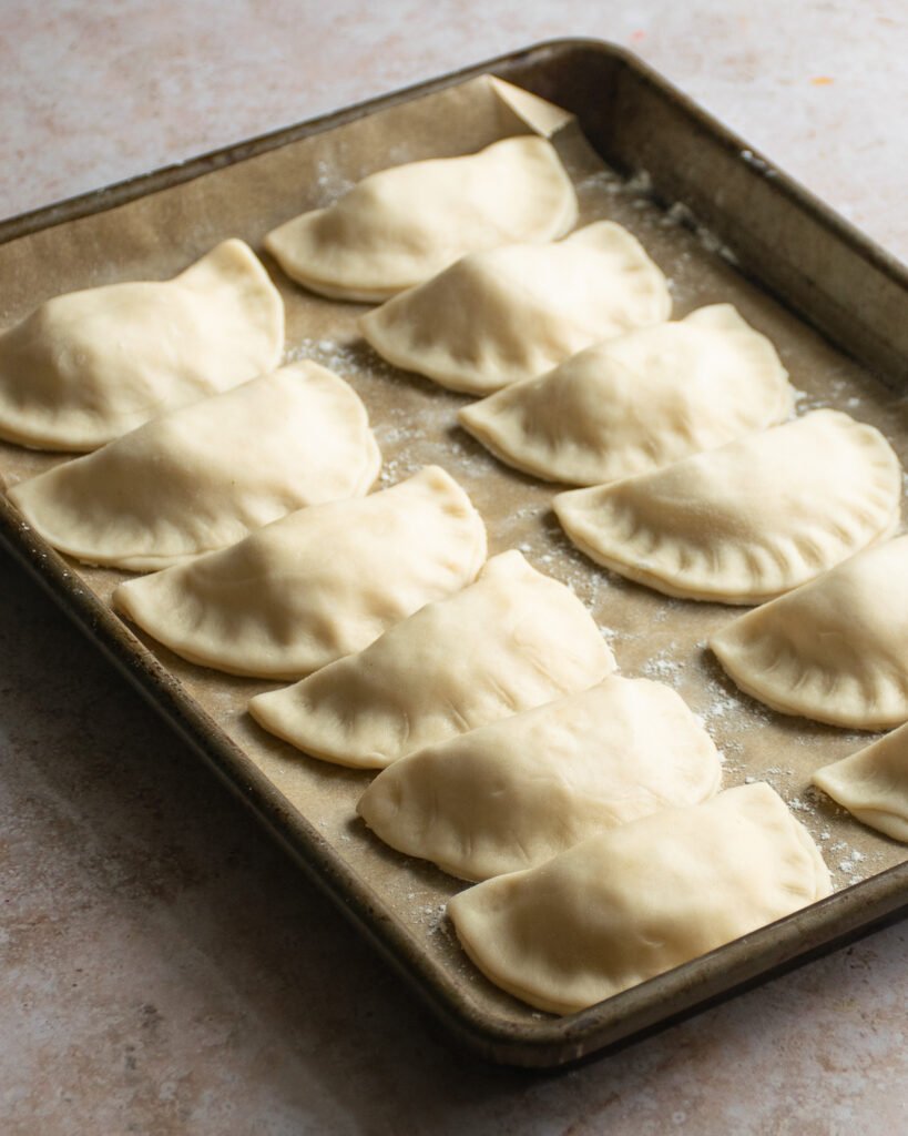 A tray of finished pierogies on a countertop.