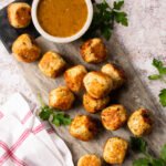 Italian Chicken Meatballs on a serving tray with a bowl of dip.