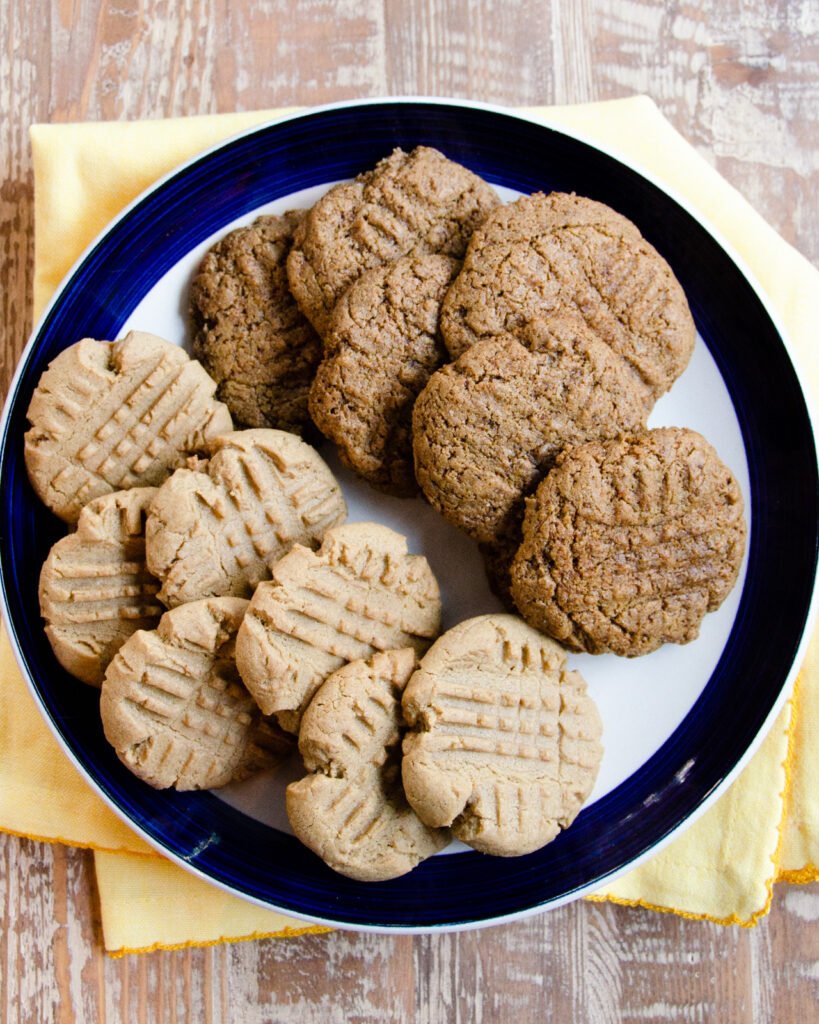 A blue rimmed plate with two types of sunbutter cookies on it.