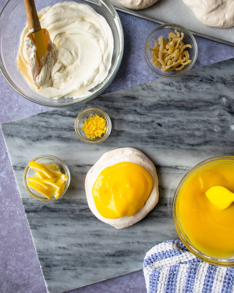 Building a mini lemon pavlova cloud on a marble surface.