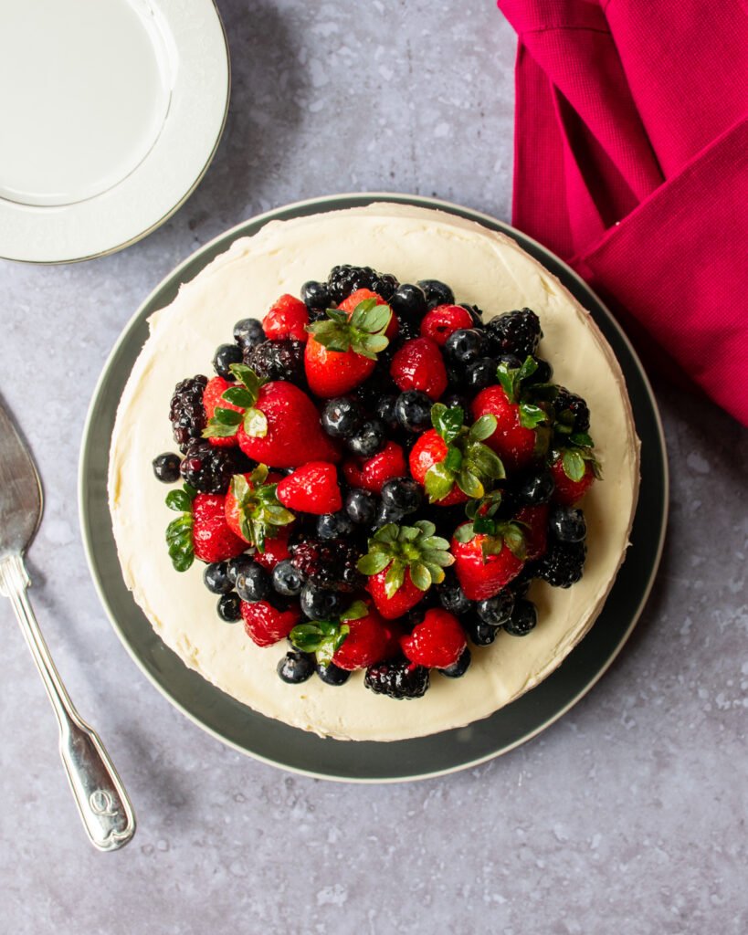 An overhead shot of a cake with berries on top.