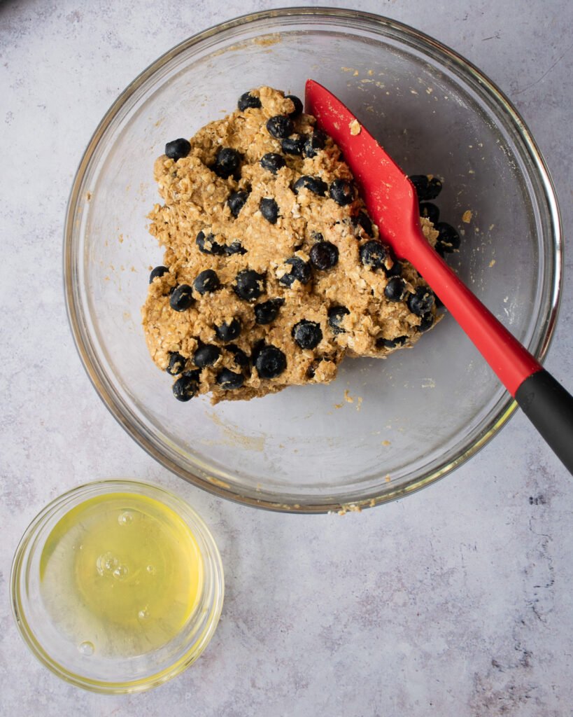 Blueberry pup-muffin dough in a bowl with a bowl of egg whites next to it.