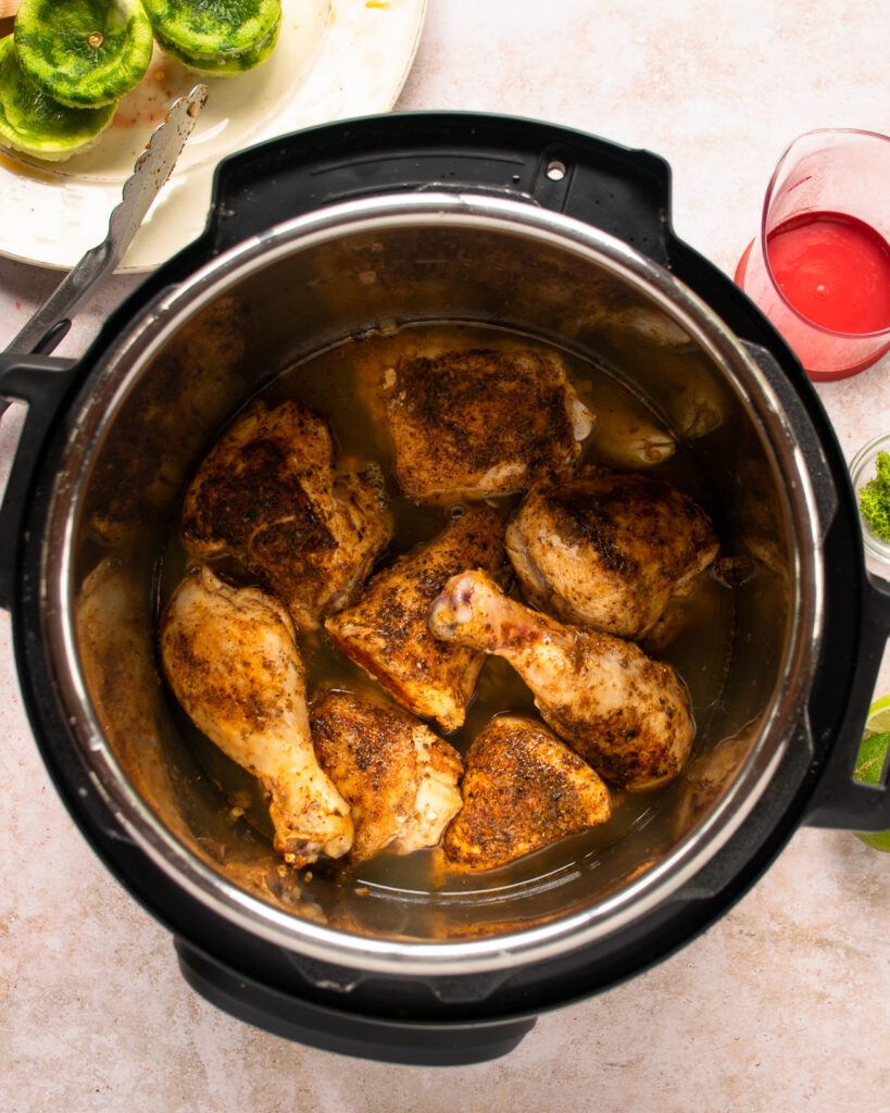 Chicken pieces browned in a pressure cooker.