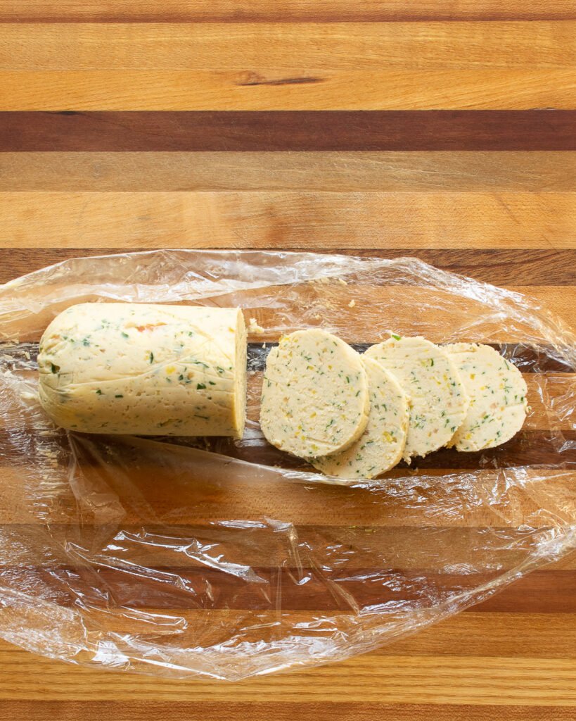 Gorgonzola shallot butter in a log on a cutting board with a few slices cut.