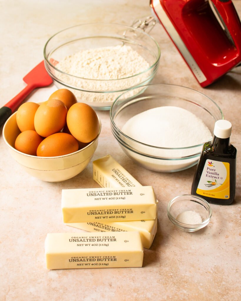 Ingredients on a counter - eggs, flour, sugar, vanilla, salt and butter.