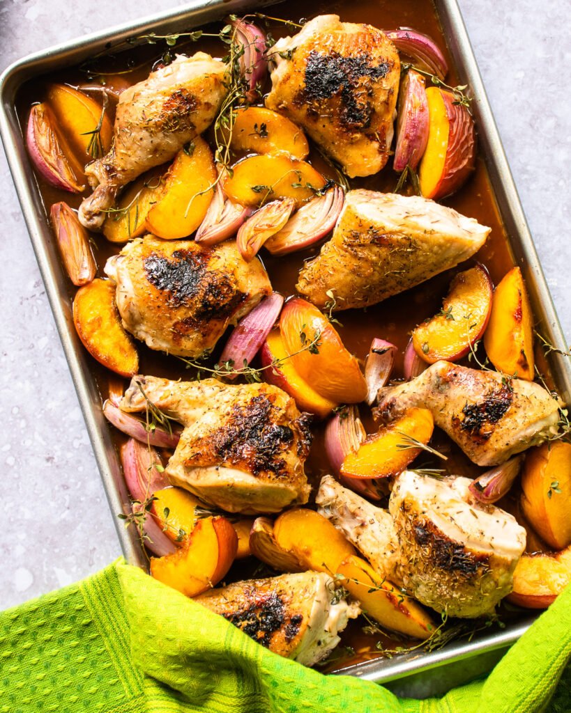 A sheet pan dinner with a green towel.