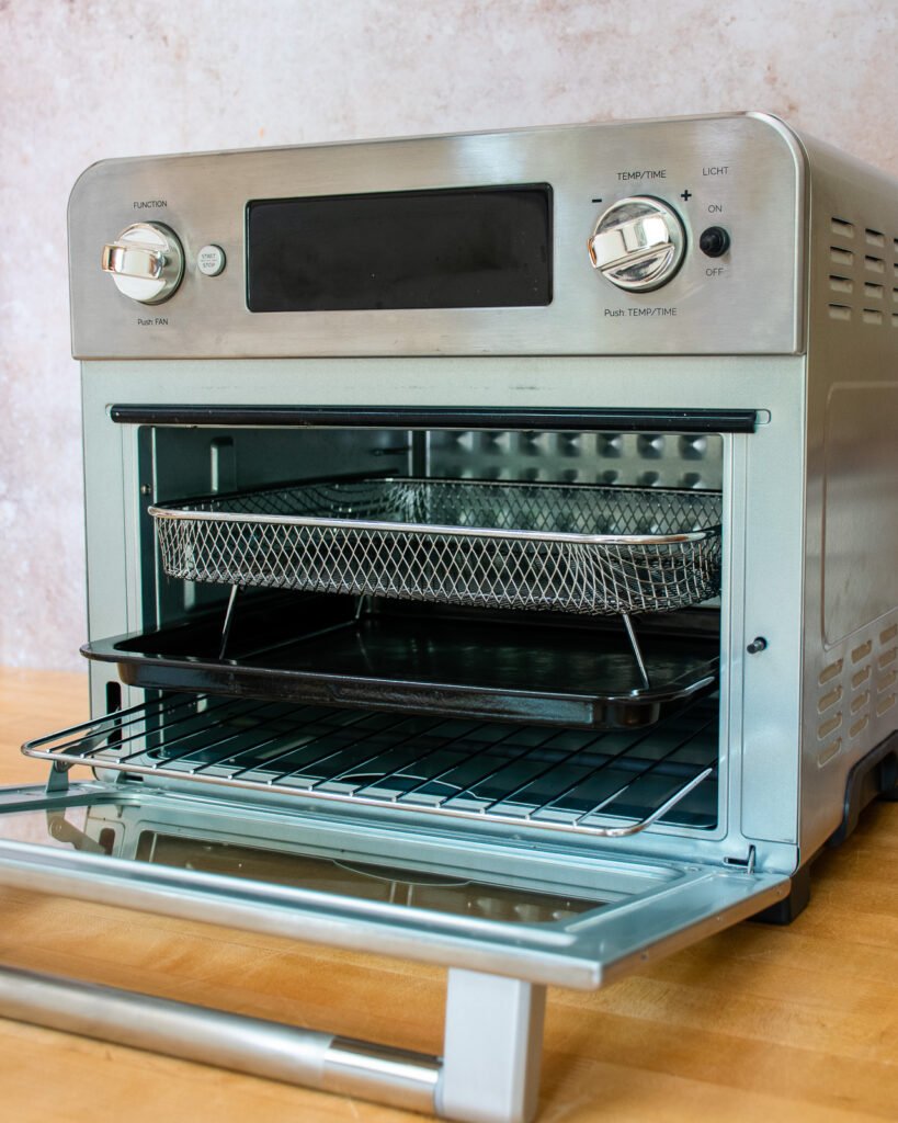 An air fryer oven with door open on a countertop.