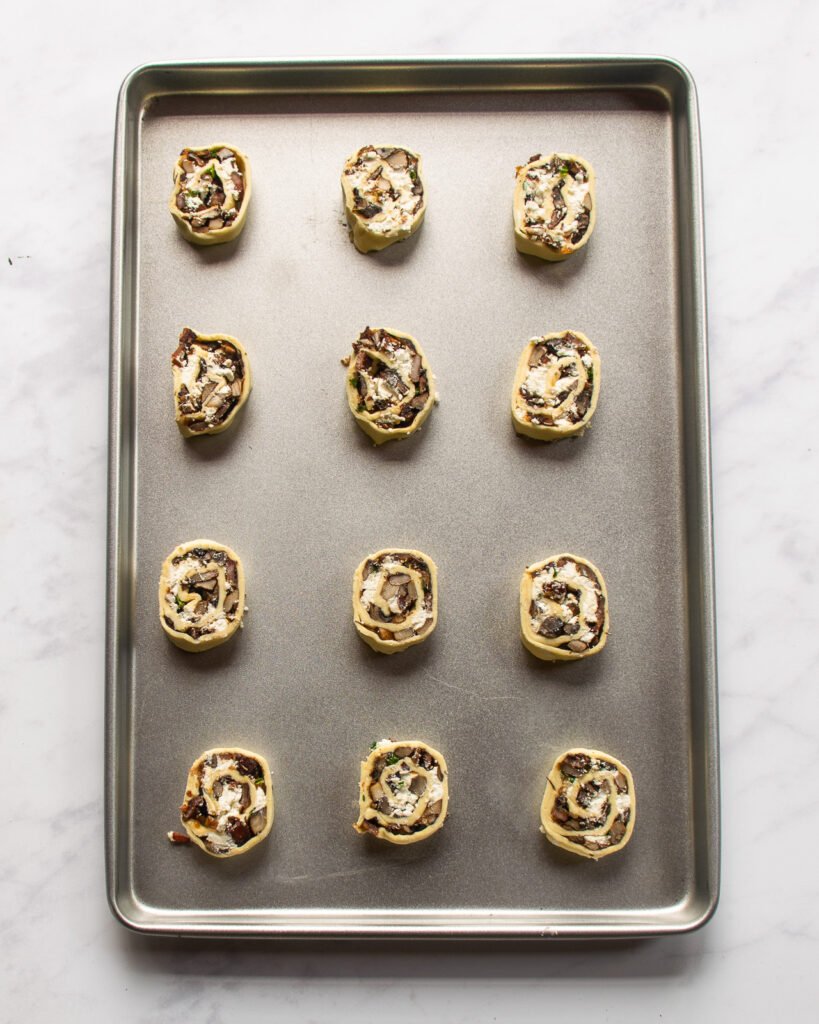 Mushroom goat cheese pinwheels on a baking sheet.
