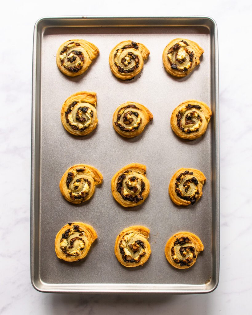 Baked pastry pinwheels on a baking sheet.
