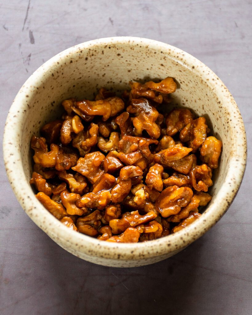 Candied walnuts in a small ceramic dish.