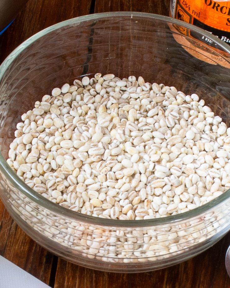 A glass bowl of raw barley.