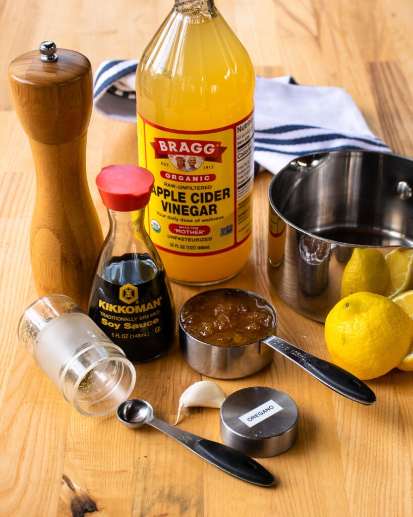 Ingredients on a wooden counter with a saucepan and measuring spoons.
