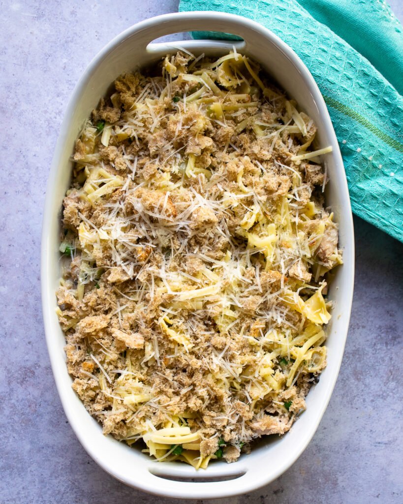 Tuna noodle casserole in an oval white casserole dish before going into the oven.