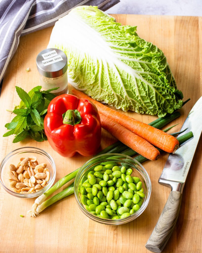 Ingredients on a wooden cutting board with a chef's knife.