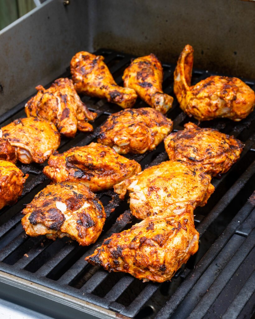 Chicken pieces on a grill.