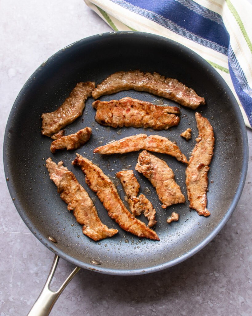 Strips of beef in a skillet.