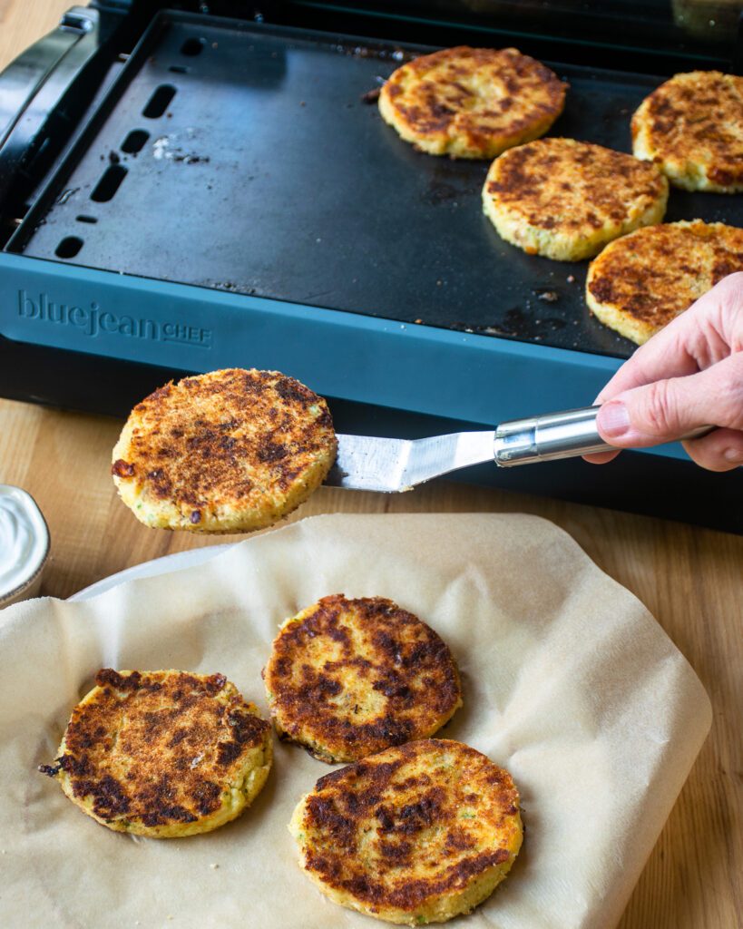 A spatula serving a portion of a potato cake onto a plate.