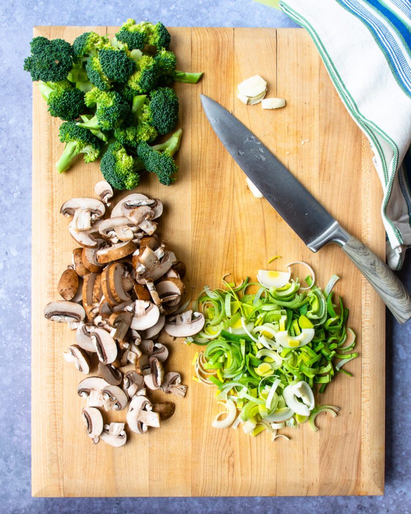Vegetables cut on a cutting board - mushrooms, leeks and broccoli.