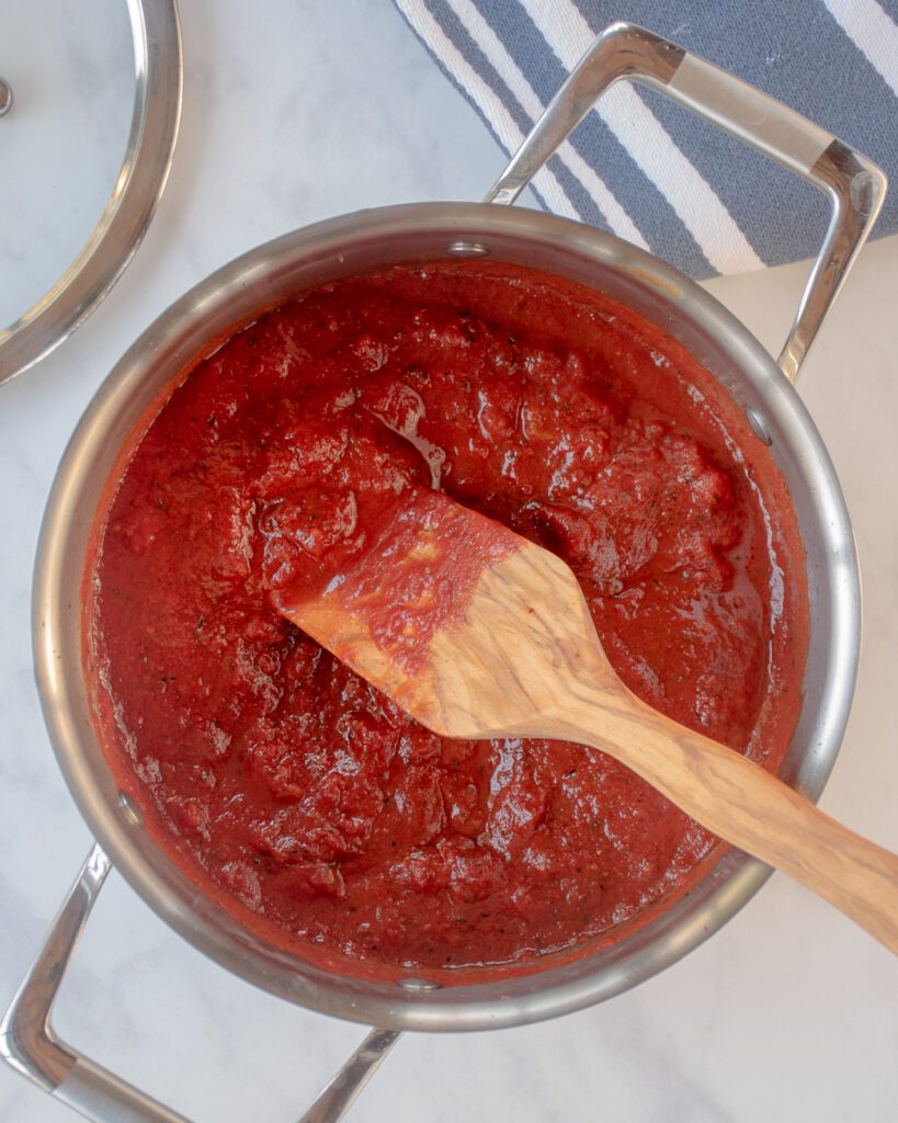 Looking down into a pot of tomato pizza sauce.