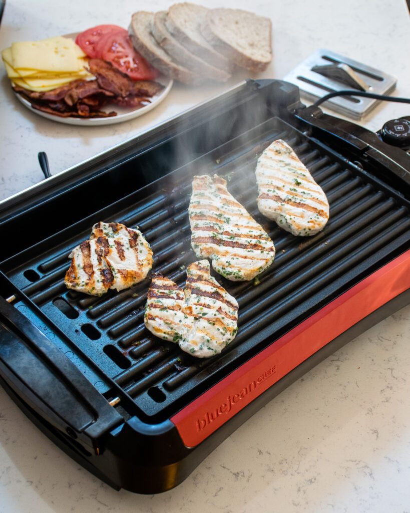 Chicken breast grilling on an electric grill.