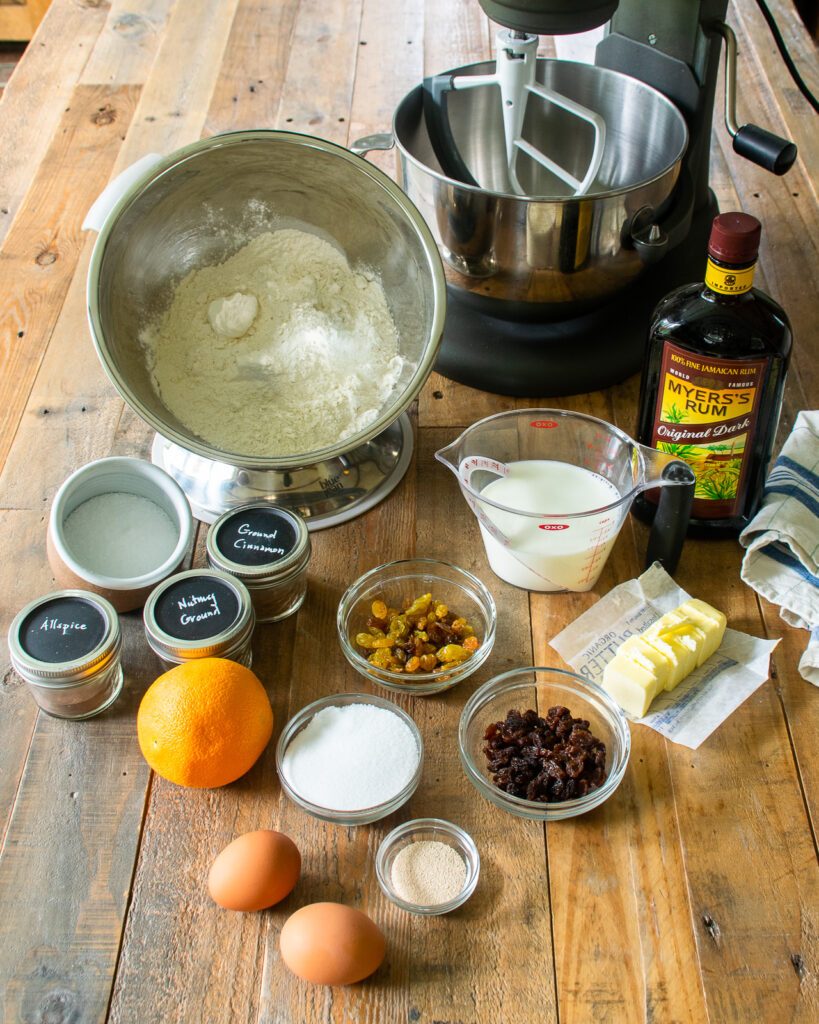 Ingredients on a wooden table with a stand mixer in the background.